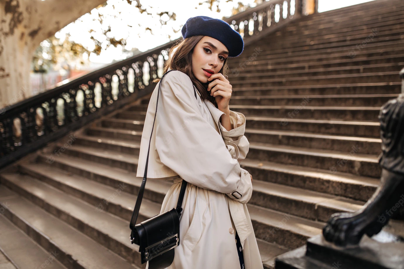 lovely-young-parisian-woman-with-brunette-hair-stylish-beret-beige-trench-coat-black-bag-standing-old-stairs-sensitively-posing-outdoors_197531-24472
